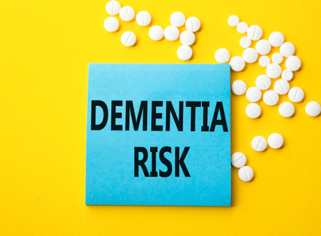 Dementia Risk symbol. Concept word Dementia Risk on blue note. Beautiful yellow background with pills. Medicine and Dementia Risk concept. Copy spaceの写真素材