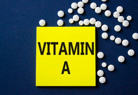 Vitamin A symbol. Concept word Vitamin A on yellow note. Beautiful deep blue background with pills. Medicine and Vitamin A concept. Copy spaceの写真素材