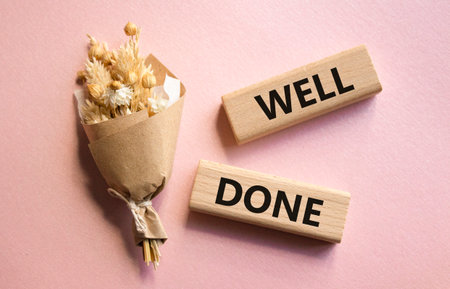 Well done symbol. Wooden blocks with words Well done. Beautiful pink background. Business and Well done concept. Copy space.の写真素材
