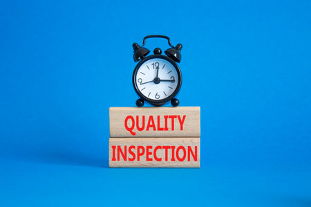 Quality Inspection symbol. Concept word Quality Inspection on wooden blocks. Beautiful blue background with alarm clock. Business and Quality Inspection concept. Copy spaceの写真素材