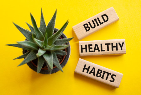 Healthy habits symbol. Concept word Build Healthy habits on wooden blocks with succulent. Beautiful yellow background. Healthy lifestyle and Healthy habits concept. Copy spaceの写真素材