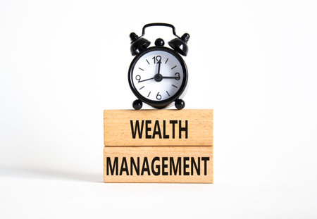 Wealth Management symbol. Concept words Wealth Management on wooden blocks. Beautiful white background with alarm clock. Business and Wealth Management concept. Copy spaceの写真素材