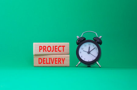Project Delivery symbol. Concept word Project Delivery on wooden blocks. Beautiful green background with alarm clock. Business and Project Delivery concept. Copy spaceの写真素材