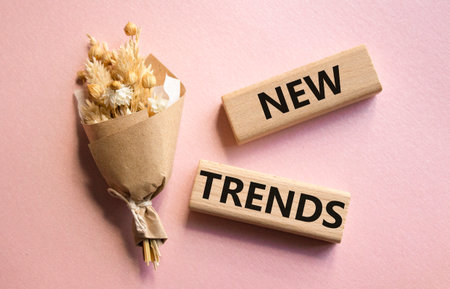 New Trends symbol. Wooden blocks with words New Trends. Beautiful pink background. Business and New Trends concept. Copy space.の写真素材