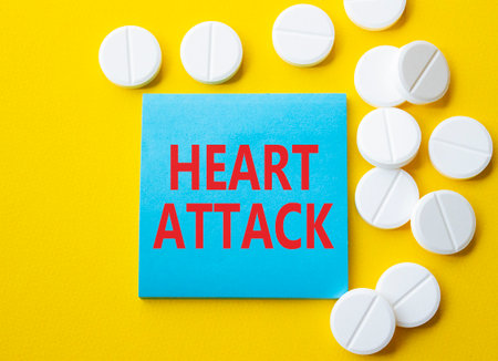 Heart Attack symbol. Concept word Heart Attack on blue note. Beautiful yellow background with pills. Medicine and Heart Attack concept. Copy spaceの写真素材