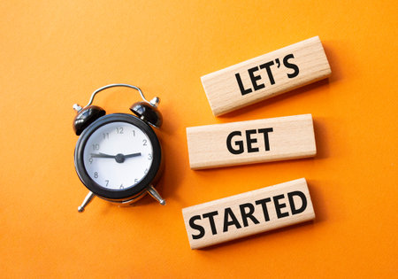 Lets get started symbol. Concept words Lets get started on wooden blocks. Beautiful orange...
