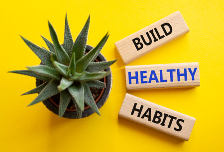 Healthy habits symbol. Concept word Build Healthy habits on wooden blocks with succulent. Beautiful yellow background. Healthy lifestyle and Healthy habits concept. Copy spaceの写真素材