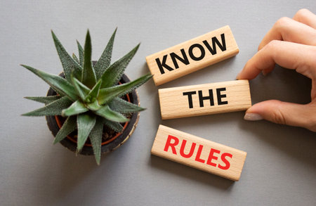 Know the rules symbol. Wooden blocks with words Know the rules. Businessman hand. Beautiful gray background with succulent plant. Business and Know the rules concept. Copy space.の写真素材
