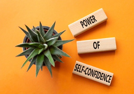 Self-Confidence symbol. Wooden blocks with words Power of Self-Confidence. Beautiful orange background with succulent plant. Business concept. Copy space.の写真素材