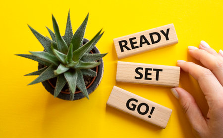 Ready Set Go symbol. Concept words Ready Set Go on wooden blocks. Beautiful yellow background with succulent plant. Businessman hand. Business and Ready Set Go concept. Copy space.の写真素材