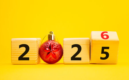 2026 New Year symbol. Businessman turns wooden cube and changes Year 2025 to 2026. Beautiful yellow...