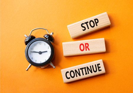 Stop or Continue symbol. Concept words Stop or Continue on wooden blocks. Beautiful orange...