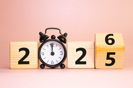 2026 New Year symbol. Businessman turns wooden cube and changes Year 2025 to 2026. Beautiful pink...