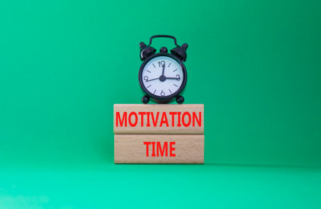 Motivation Time symbol. Concept word Motivation Time on wooden blocks. Beautiful green background with alarm clock. Business and Motivation Time concept. Copy spaceの写真素材