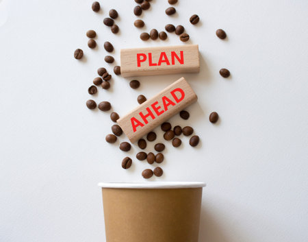 Plan ahead symbol. Wooden blocks with words Plan ahead. Beautiful white background with coffee cup and coffee beans. Business and Plan ahead concept. Copy space.の写真素材