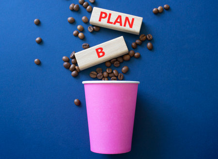 Plan B symbol. Wooden blocks with words Plan B. Beautiful deep blue background with coffee cup and coffee beans. Business and Plan B concept. Copy space.の写真素材