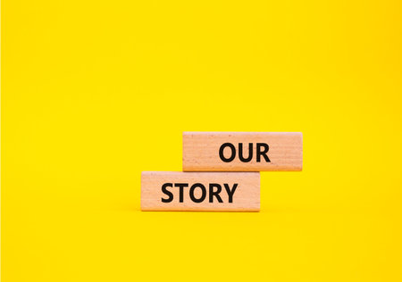 Our story symbol. Wooden blocks with words Our story Beautiful yellow background. Business and Our...