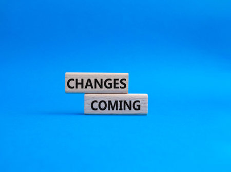 Changes Coming symbol. Wooden blocks with words Changes Coming. Beautiful blue background. Health...