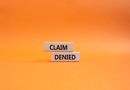 Claim denied symbol. Wooden blocks with words Claim denied. Beautiful orange background. Business...
