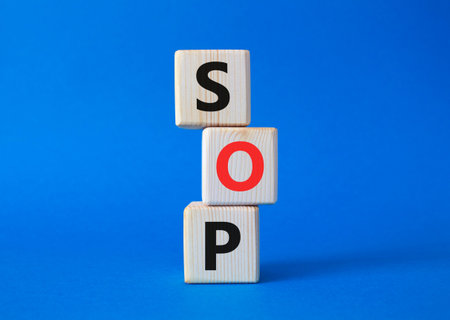 SOP - Standard Operating Procedure symbol. Wooden blocks with words SOP. Beautiful blue background....