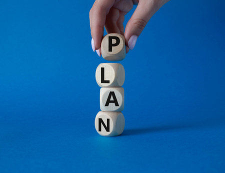 Plan symbol. Concept word Plan on wooden cubes. Businessman hand. Beautiful blue background. Business and Plan concept. Copy space.の写真素材