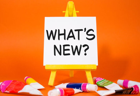 What is new symbol. Concept word What is new on wooden blocks. Beautiful orange background with...