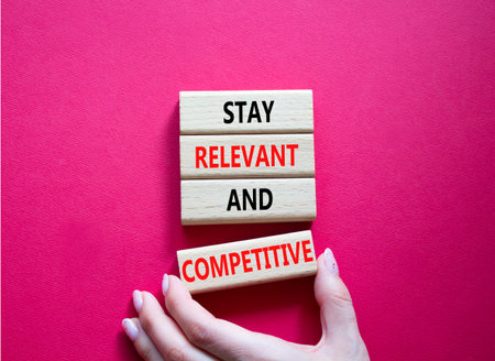 Relevant and Competitive symbol. Concept words Stay Relevant and Competitive on wooden blocks....