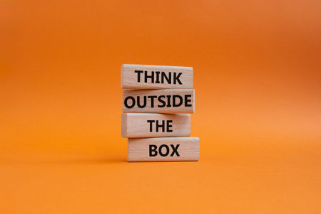 THINK OUTSIDE THE BOX symbol. Wooden blocks with words THINK OUTSIDE THE BOX. Beautiful orange background. Business and THINK OUTSIDE THE BOX concept. Copy spaceの写真素材