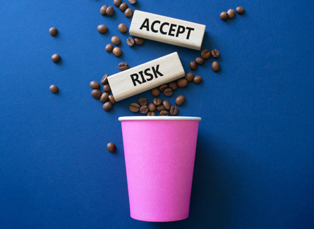 Accept Risks symbol. Concept words Accept Risks on beautiful wooden picture frame. Beautiful deep blue background with coffee cup and coffee beans. Business and Accept Risks concept. Copy space.の写真素材