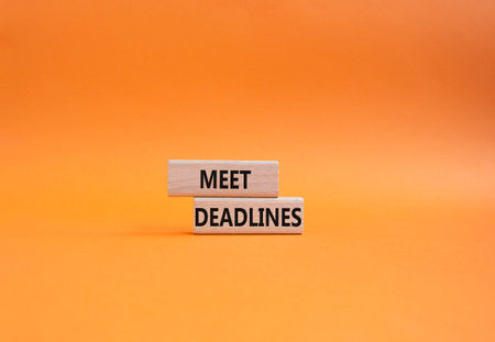 Meet Deadlines symbol. Concept word Meet Deadlines on wooden blocks. Beautiful orange background....