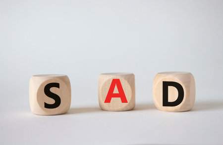 Sad symbol. Wooden cubes with words Sad. Beautiful white background. Business and Garden concept....