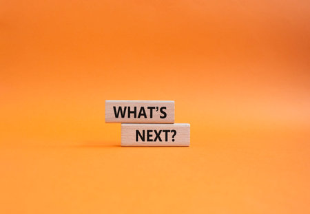 What is next symbol. Concept words What is next on wooden blocks. Beautiful orange background. Business and What is next concept. Copy space.の写真素材