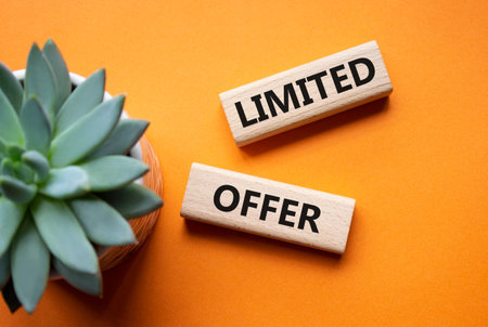 Limited offer symbol. Concept word Limited offer on wooden blocks. Beautiful orange background with...