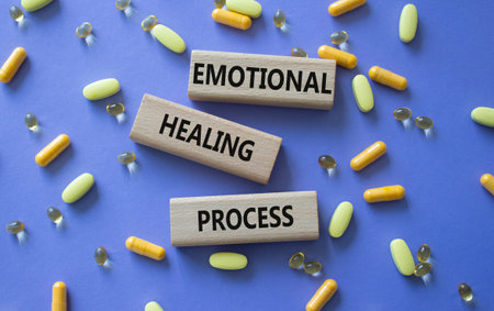 Emotional Healing Process symbol. Concept words Emotional Healing Process on wooden blocks. Beautiful purple background with pills. Healthcare and Emotional Healing Process concept. Copy space.