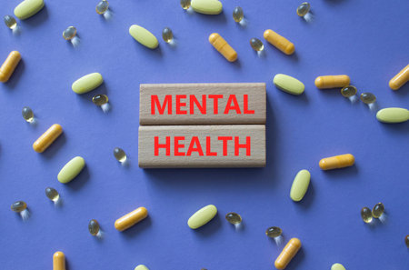 MENTAL HEALTH symbol. Concept word MENTAL HEALTH on wooden blocks. Beautiful purple background with pills. Medicine and MENTAL HEALTH. Copy space