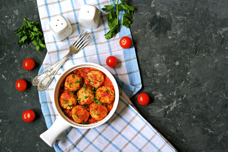 Fish meatballs in tomato sauce in a white ceramic pan on a dark concrete background. Top view. Seafood.の写真素材
