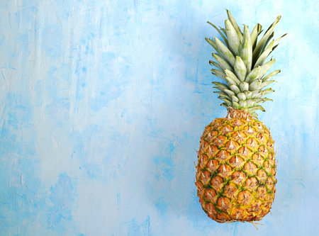 Ripe and juicy whole pineapple on a light blue concrete background. Tropical fruit. Summer concept....