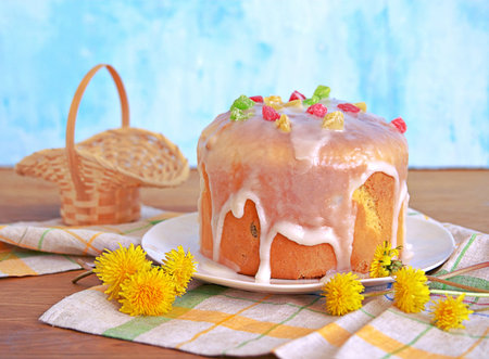 Traditional Easter cake on a white plate, decorated with icing sugar and candied fruits. Happy...