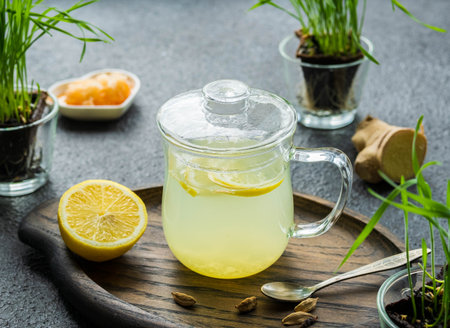 Ginger tea with lemon in a glass mug on a dark concrete background. Hot drink recipes.の写真素材
