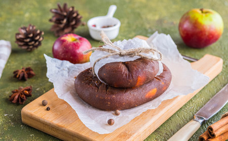 Lithuanian dessert, sweet apple fruit candy in the form of heads of cheese with spices on a wooden...