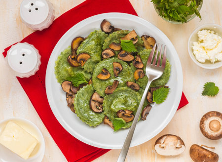 Round nettle ravioli stuffed with mushrooms and curd cheese in a gray ceramic plate on a light concrete background. Recipes with wild herbs. Italian foodの写真素材