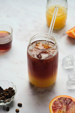 Bumble coffee, coffee cocktail with orange juice, syrup and ice in transparent jar-shaped glasses on...