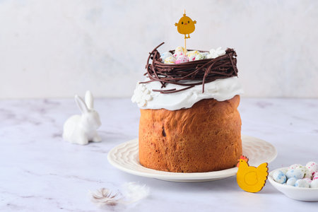 Easter cake covered with icing with a decor of a chocolate nest with eggs and a chicken topper on a...