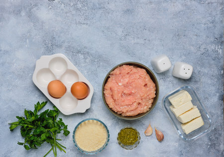 Step-by-step cooking of meatballs stuffed with feta and pesto sauce. Step one, prepared ingredients on a gray concrete background. Step-by-step recipes. Minced meat recipesの写真素材
