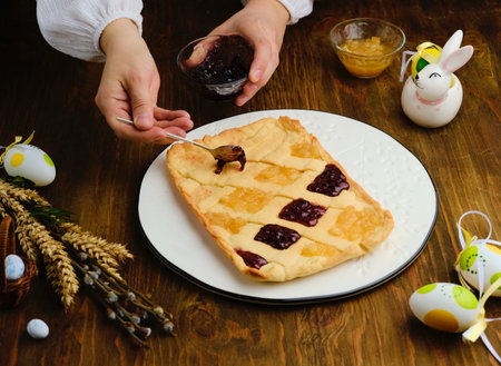 A woman in a white blouse fills with a jam Mazurek, a traditional Polish Easter sweetness from sand...