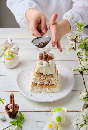 Decorating cottage cheese Easter in the style of tiramisu with cottage cheese cream and cookies on a...