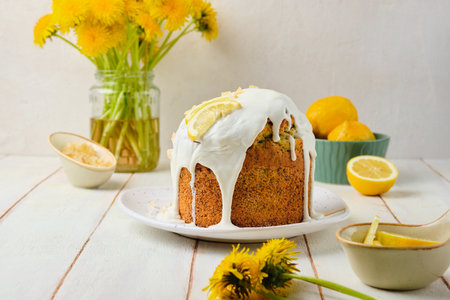 Cake with lemon filling and poppy seeds, covered with sugar icing, on a ceramic plate on a light concrete background. Baking recipes with poppy seeds. Cake Recipes.の写真素材