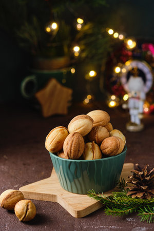 Homemade cookies Nuts from shortcrust pastry with caramel and nut filling in a green bowl on a brown concrete background. Traditional Christmas cookies. Merry Christmasの写真素材