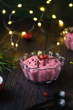 Vegan cranberry mousse on semolina in a transparent glass bowl, decorated with gratified chocolate and cranberries on a wooden background in Christmas decor. Merry Christmas. Latvian cuisineの写真素材