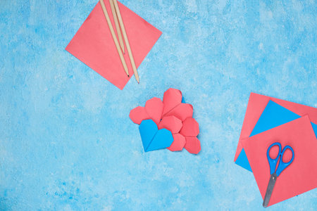 Origami heart made of red and blue paper on a blue concrete background. Creativity, craft, paper crafts. Valentine's Day. Souvenirs for loversの写真素材